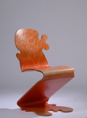 une chaise en bois dont l'assise est cassée, posée sur une surface blanche