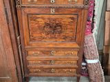 a wooden chest of drawers in a room with a rug