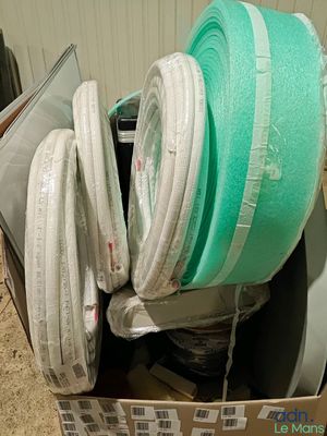 une boîte remplie de différents types de matelas posée par terre