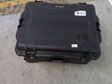 a black case sitting on the ground next to a white wall