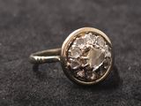 un gros plan d'une bague en or sertie d'un diamant blanc