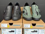 trois paires de chaussures Shimano posées sur des cartons