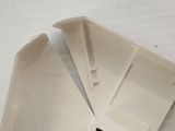 two pieces of white plastic on a white surface