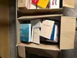 des boîtes de livres sont empilées dans une pièce