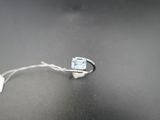 une image représentant une bague sertie d'une topaze bleue sur un fond noir