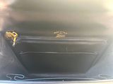 the inside of a black purse with a gold handle