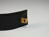 a close up of a black leather belt with a gold buckle