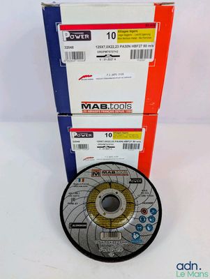 un gros plan d'un disque posé sur une surface blanche, à côté d'une boîte