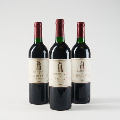 trois bouteilles de vin rouge posées l'une à côté de l'autre sur une surface blanche