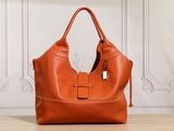 a brown leather handbag sitting on top of a wooden table