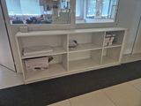 a white book shelf with a mirror on top of it