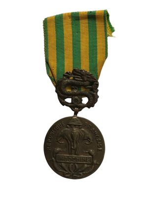 une vieille médaille en bronze ornée d'un ruban vert, jaune et rouge