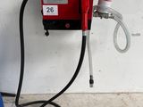 une pompe à essence rouge à laquelle est raccordé un tuyau