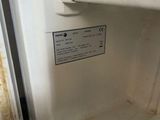 a dirty refrigerator with a door open and a sign on the door