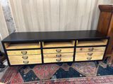 une commode noire et jaune posée sur un tapis