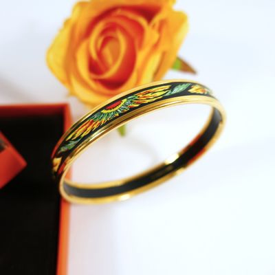 a yellow rose and a black box with a ring on it