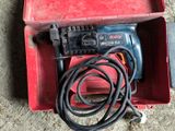 a red box with a drill and a cord in it