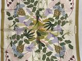 un gros plan sur un foulard carré orné de fleurs et de feuilles