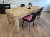 une table en bois avec deux chaises et une lampe posée dessus