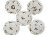 quatre assiettes sur lesquelles sont peints des oiseaux et des fleurs sur un fond blanc
