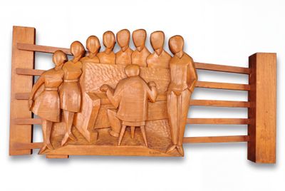 wooden sculpture of a group of people on a fence