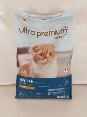 un chat orange et blanc assis sur un sac de croquettes pour chat
