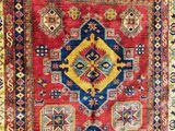 a red, blue and yellow rug with a diamond design