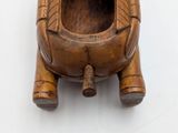 a small wooden object that is on a white surface