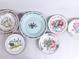 many plates with different designs on them on a white surface