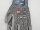une paire de gants de travail gris posés sur une surface blanche