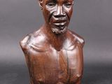 an image of a wooden bust of a man on a black background