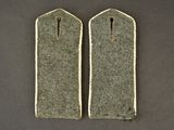 two army uniform tags on a table with a black background