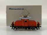 a toy train on a white surface with a box in the background