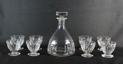 une image représentant une carafe en verre et quatre verres sur fond noir