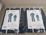 two pairs of men ' s pajamas in plastic bags sitting on a table