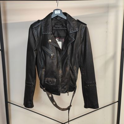 une veste en cuir noir suspendue à un portant dans une pièce