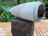 un vase en ciment posé sur une table en bois