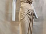 une photo d'un mannequin portant une robe beige, posé sur un support de mannequin