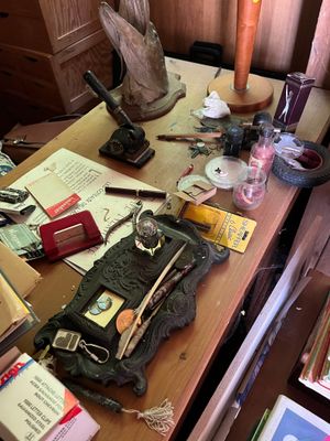 un bureau encombré, sur lequel s'entassent toutes sortes d'objets