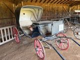 un cheval et une calèche dans une grange entourée d'une clôture