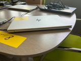 two laptops sitting on a table with a yellow sticker on it