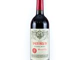 une bouteille de vin rouge posée sur une table blanche
