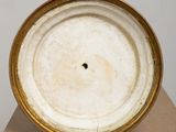 an image of a white and gold plate sitting on top of a cardboard box