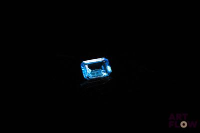 gros plan d'un diamant bleu sur une surface noire