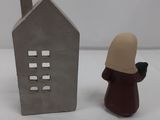 a small figurine of a person standing next to a house