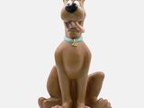 the figurine of scooby is sitting on a white surface