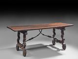 une vieille table en bois aux pieds sculptés et au plateau en bois