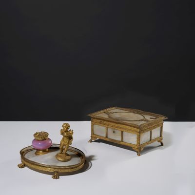 a small gold box with a figurine on top of it