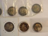 several coins are in plastic bags on a white surface
