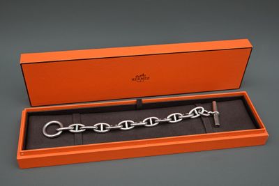 une boîte orange contenant un bracelet à chaîne argentée